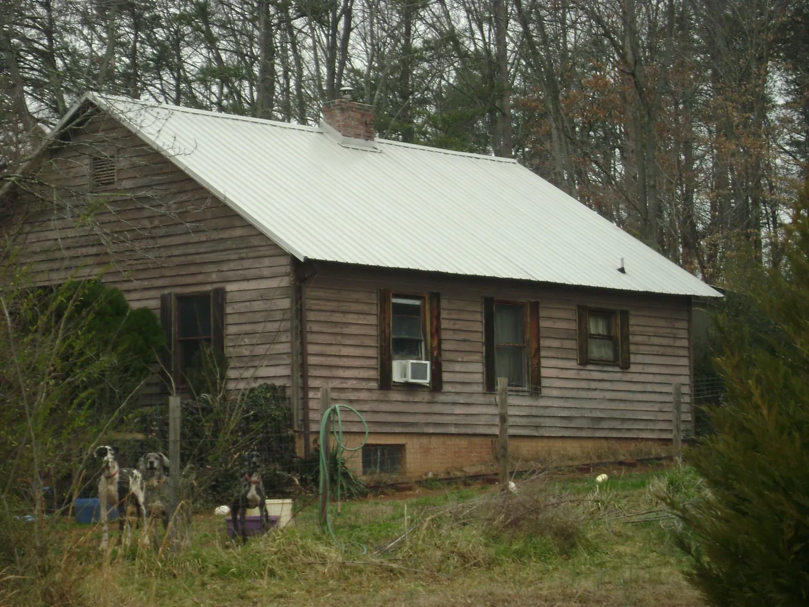White metal roof on an old wood sided farmhouse, from a Metal Roof Installation job in Greensboro